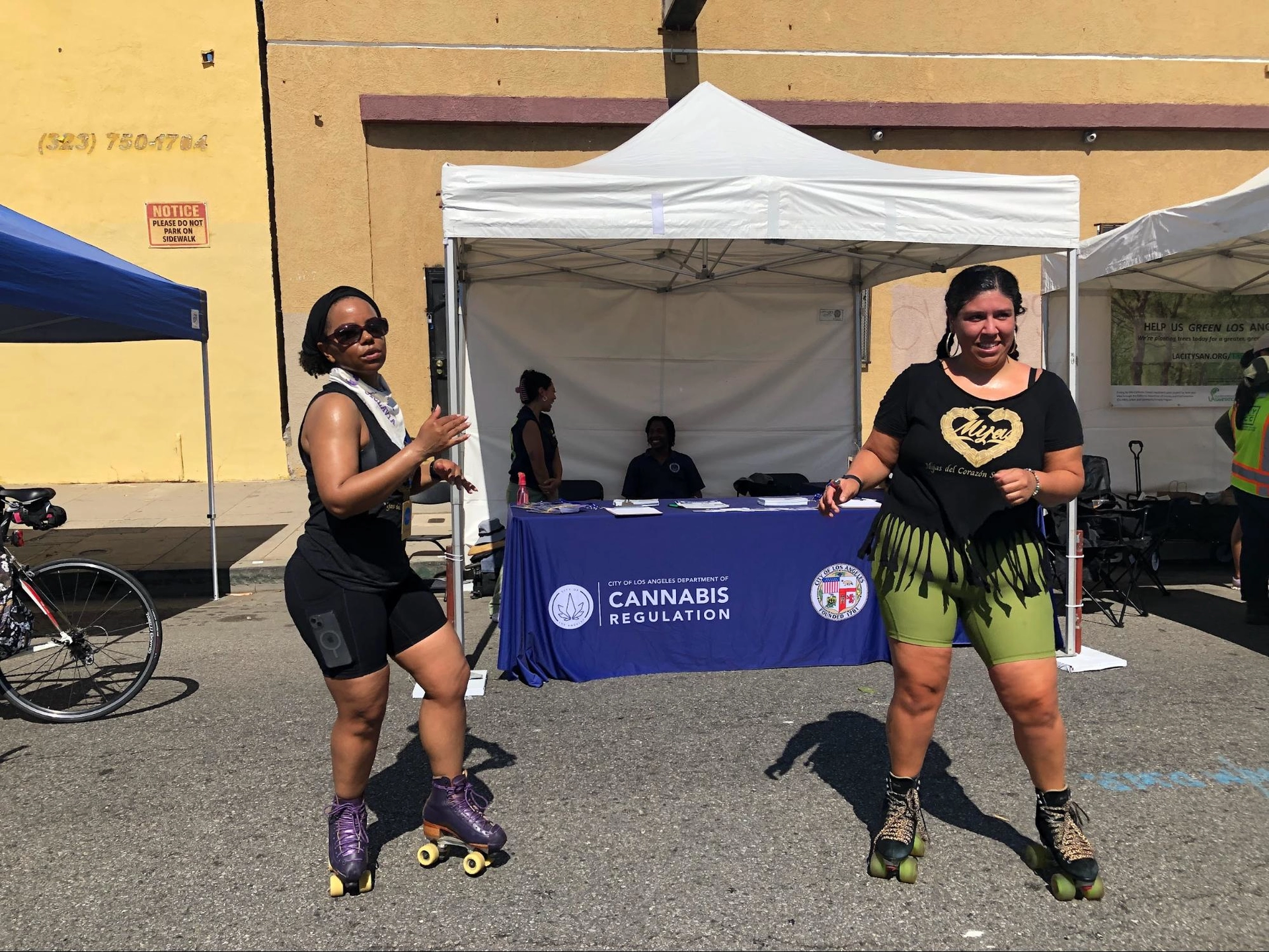 Two women on skates in front of a tent